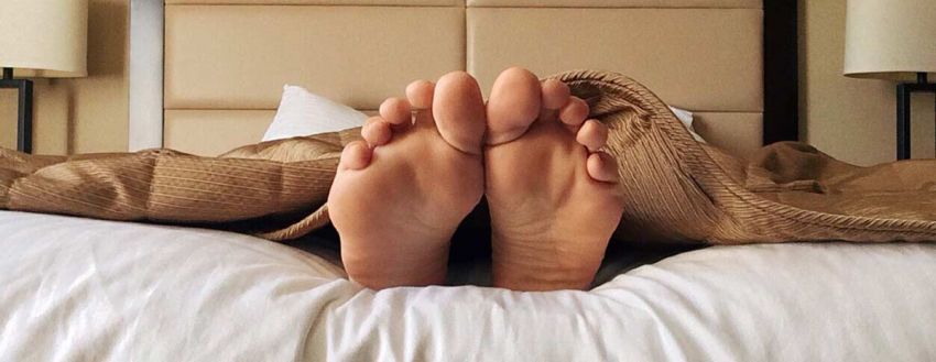 Füße schauen unter der Decke heraus